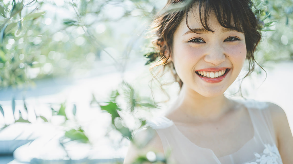 ウェディングドレス姿でブーケを微笑む花嫁